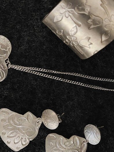 Jewelry made of silver with filigree patterns. The collection includes a necklace, earrings, and a bracelet. | © Lisa Wagenhofer