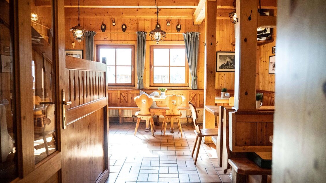 Ein gemütliches Restaurant mit Holzwänden und großen Fenstern. Die Einrichtung besteht aus rustikalen Tischen und Stühlen, die eine einladende Atmosphäre schaffen. | © Chris Gütl