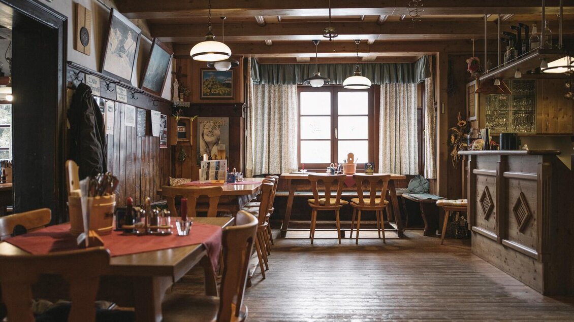 Ein rustikales Restaurant mit Holzmöbeln und einem einladenden Ambiente. Große Fenster sorgen für viel Tageslicht. | © Stefan Leitner