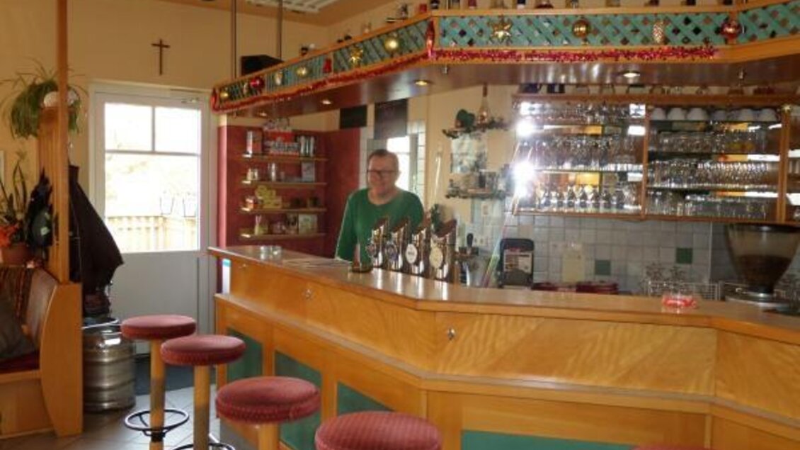 Eine gemütliche Bar mit Holztheke und Barhockern. Ein Barkeeper steht hinter der Theke und sorgt für eine angenehme Atmosphäre. | © Magdalena Stüberl