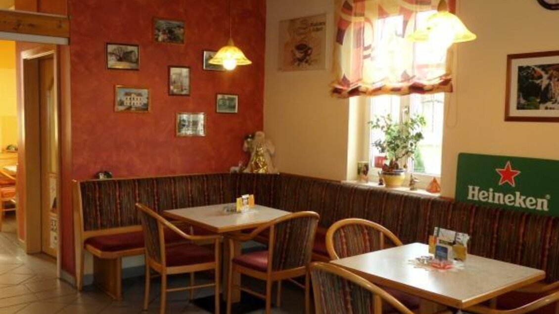 Ein gemütliches Restaurant mit Holzstühlen und Tischen. Die Wände sind in warmen Farben gestaltet und mit Bildern dekoriert. | © Magdalena Stüberl