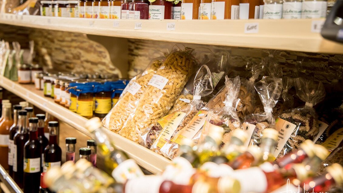 Ein Regalsystem mit verschiedenen Lebensmitteln, darunter Pasta, Marmelade und Flaschen. Die Produkte sind ordentlich angeordnet und zeigen eine vielfältige Auswahl. | © Fred Lindmoser
