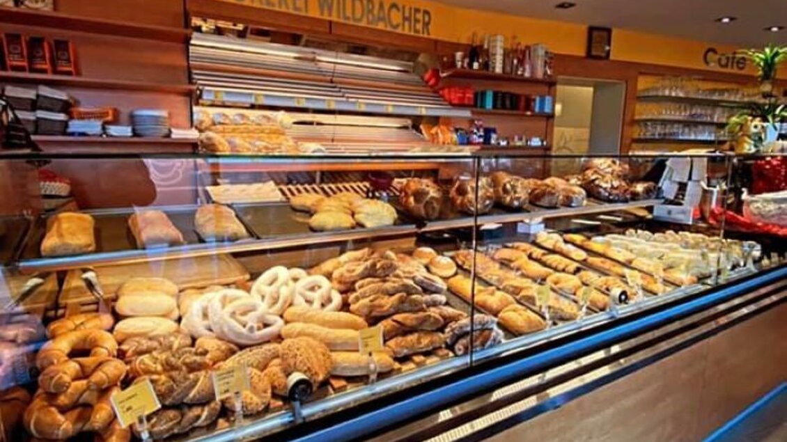 Eine Bäckerei mit einem großen Angebot an frisch gebackenem Brot und Gebäck. Die Vitrine zeigt eine Vielzahl von hochwertigen Backwaren in einladendem Ambiente. | © Marktcafe Wildbacher