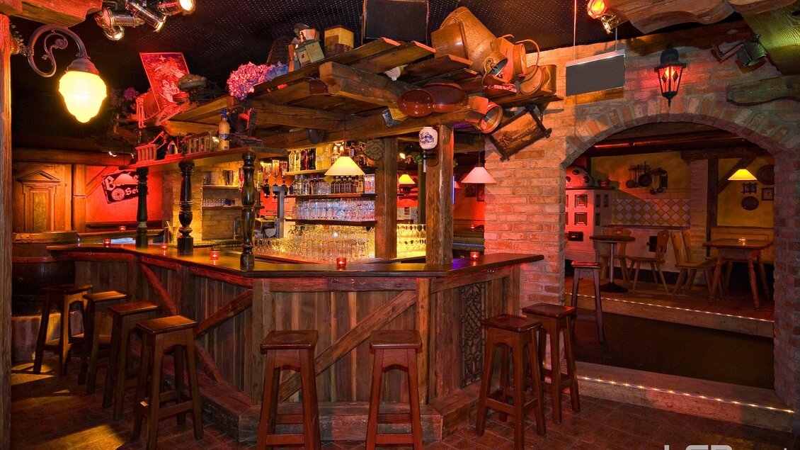 Eine gemütliche Bar mit Holztheke und Stühlen. Das warme Licht schafft eine einladende Atmosphäre. | © Mausefalle