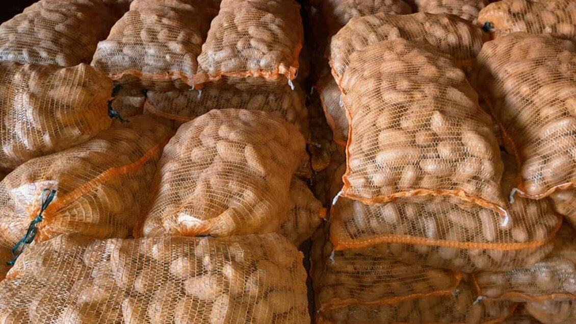 Säcke voller Erdnüsse liegen übereinander gestapelt. Die Erdnüsse sind in netzartigen Verpackungen. | © Moar in Niederdorf