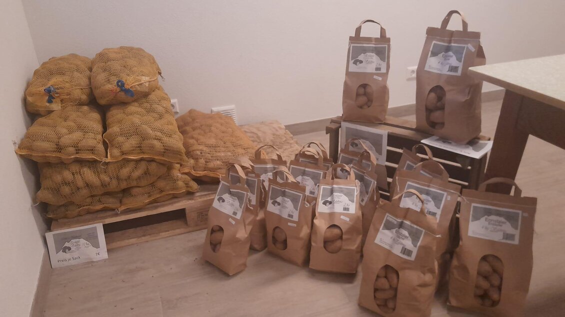 Ein Raum mit mehreren Säcken und Tüten, die gefüllte Kartoffeln enthalten. Die Tüten sind braun und mit Etiketten versehen. | © Moar in Niederdorf