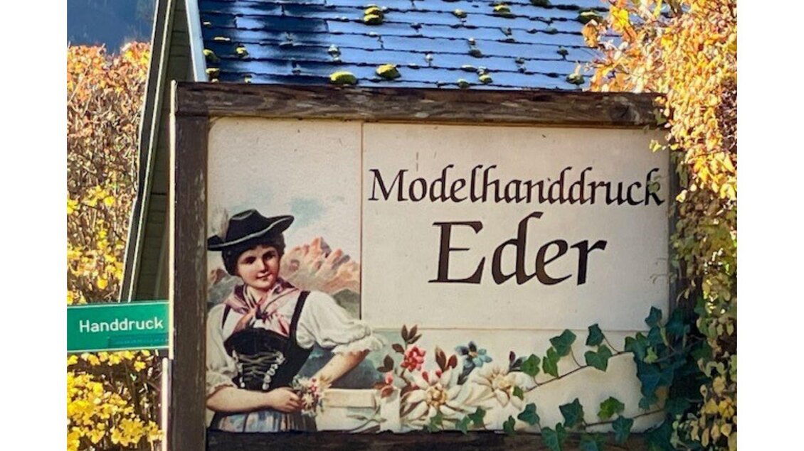 Eine malerische Brücke über einen Fluss, umgeben von bunten Blumen und charmanten Häusern. Im Hintergrund sind grüne Bäume zu sehen, die eine ruhige Atmosphäre schaffen. | © TVB Ausseerland - Salzkammergut_Heike Temmel