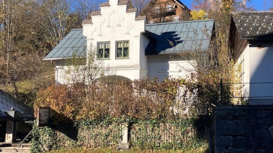 Ein charmantes Haus mit einer einzigartigen architektonischen Gestaltung und einem begrünten Garten. Der klare Himmel und die umgebende Natur verleihen der Szene eine ruhige Atmosphäre. | © TVB Ausseerland - Salzkammergut_Heike Temmel