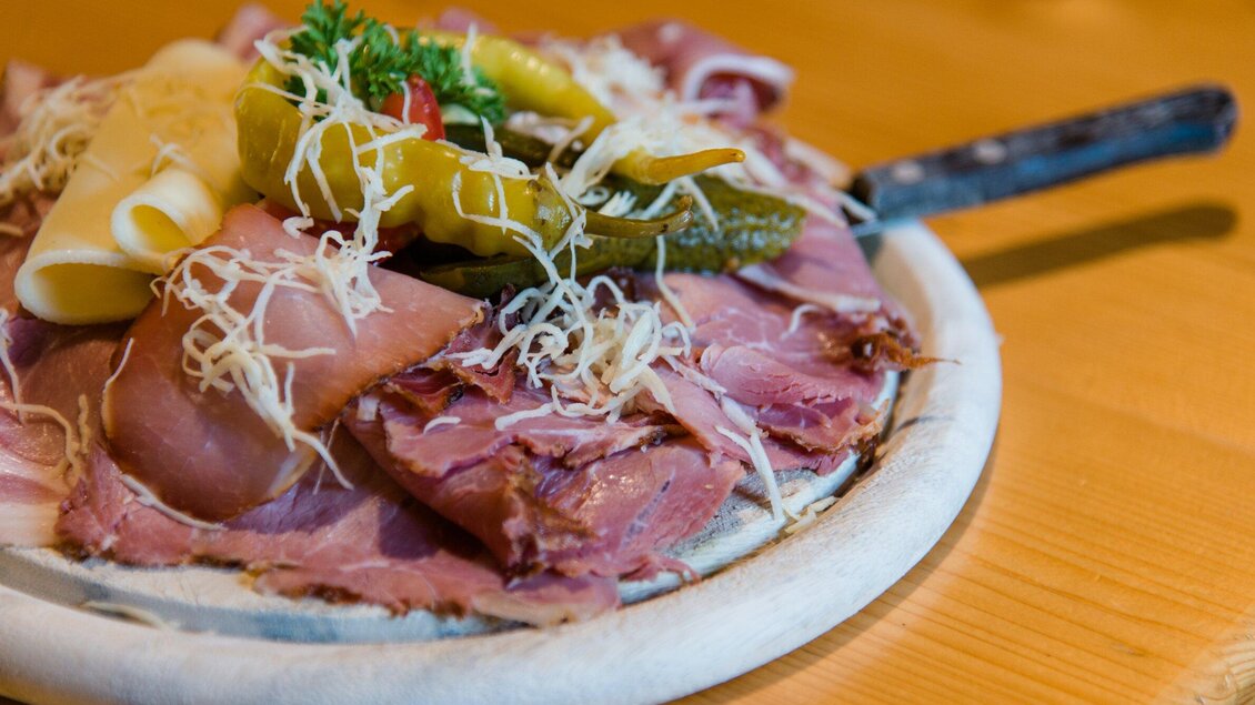 Eine Platte mit verschiedenen Fleischsorten, Käse und Gemüse. Frisch garniert mit Sauerkraut und Gewürzgurken. | © TV Region Graz - Mias Photoart