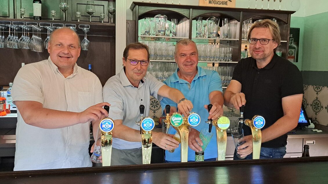 Vier Männer stehen hinter einer Bar und zapfen Bier. Im Hintergrund sind Gläser und Flaschen zu sehen. | © Johannes Ulrich