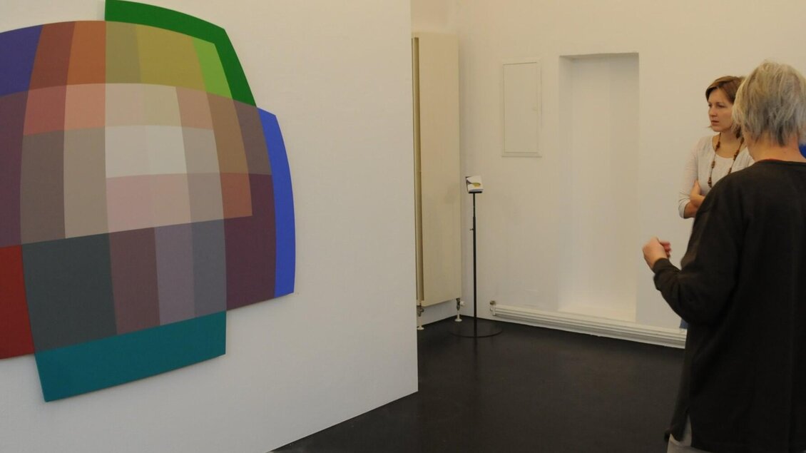 Besuchergruppe betrachtet ein farbintensives Wandbild im Museum der Wahrnehmung Graz. | © MUWA