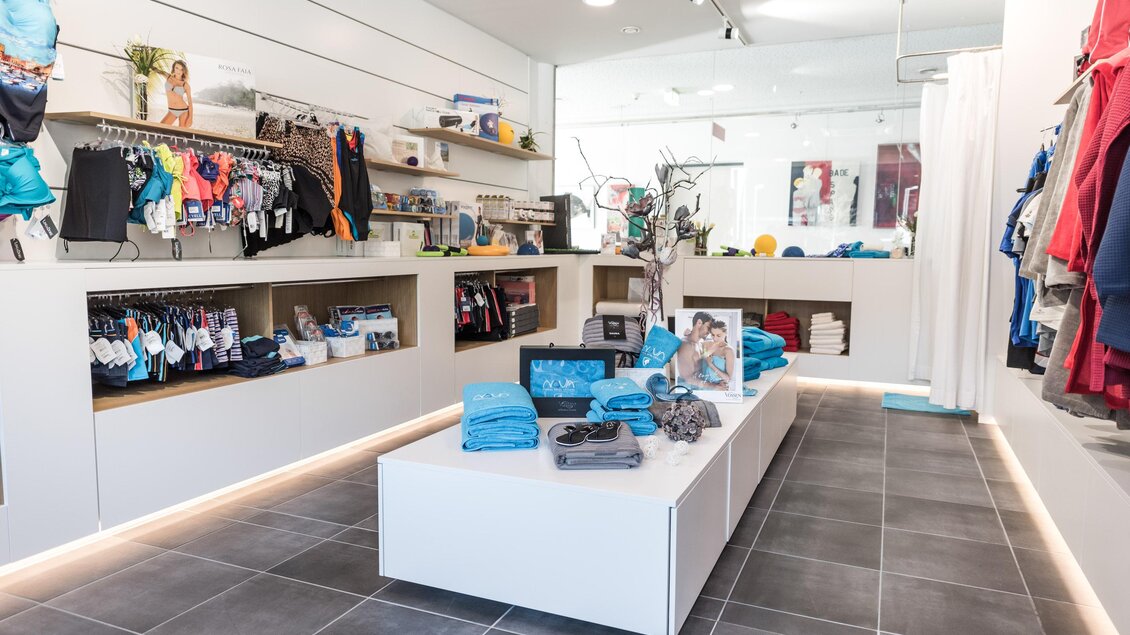 Ein moderner Einzelhandelsraum mit Regalen voller Kleidung und Accessoires. Der Boden ist gefliest und die Wände sind hell, was eine einladende Atmosphäre schafft. | © Hotel & Therme NOVA