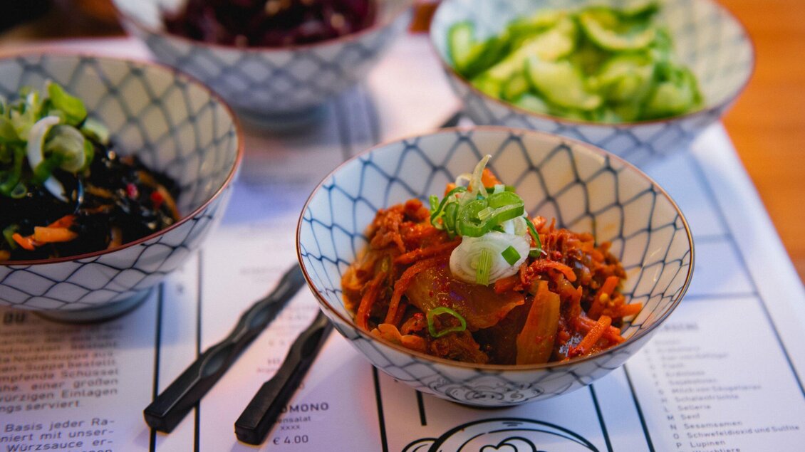 Eine Auswahl an kleinen Schalen mit buntem Gemüse. Im Vordergrund ist eine Schale mit karottenähnlichem Gemüse und Frühlingszwiebeln. | © Noonbar - Moriwano Group