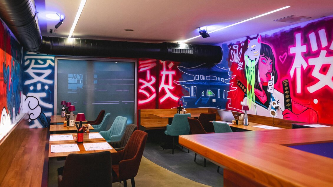 Ein modernes Restaurant mit bunten Graffiti-Wänden. Die Einrichtung ist stilvoll und bietet eine einladende Atmosphäre. | © Noonbar - Moriwano Group