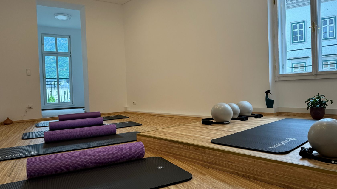 Ein heller und moderner Yogaraum mit Matten und Pilates-Geräten. Große Fenster lassen viel Tageslicht herein und sorgen für eine entspannte Atmosphäre. | © Now Pilates