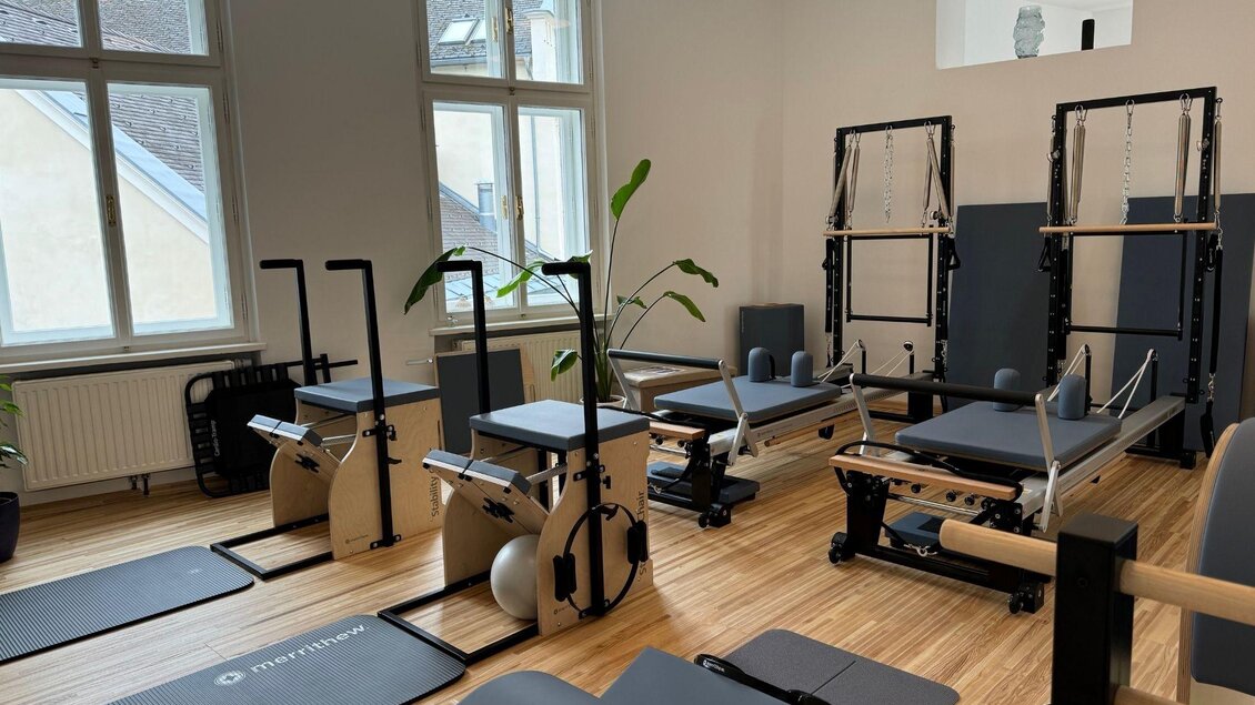 Ein modernes Fitnessstudio mit verschiedenen Trainingsgeräten und einer hellen, einladenden Atmosphäre. Große Fenster sorgen für viel Tageslicht. | © Anna Maria Kroll