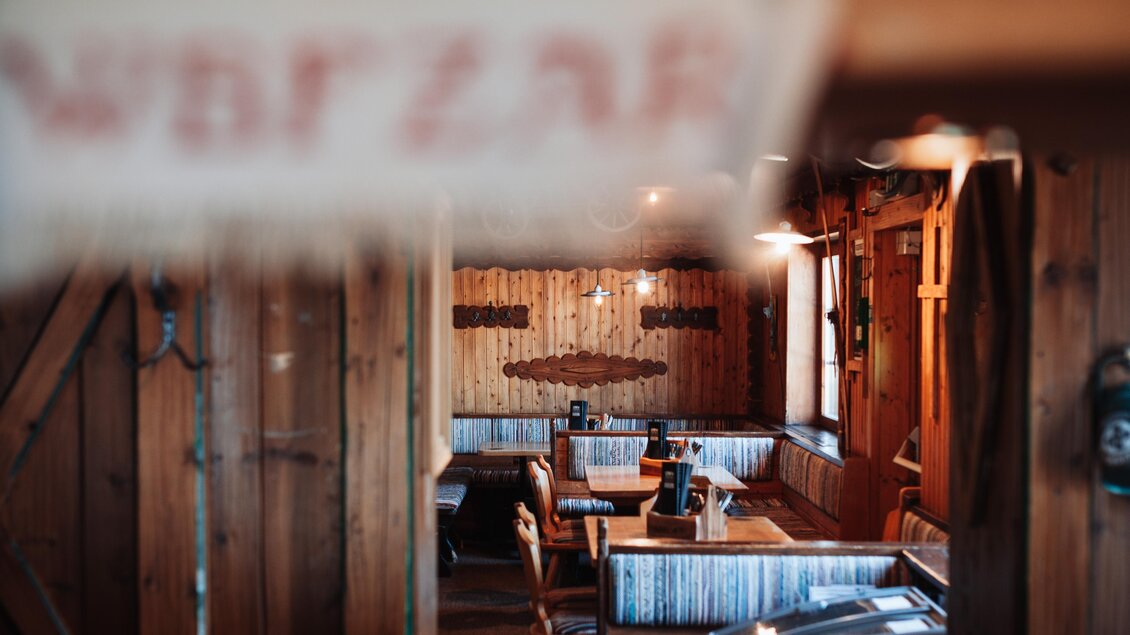 Ein gemütliches Restaurant mit Holzwänden und traditionellen Sitzgelegenheiten. Der Raum ist warm beleuchtet und lädt zum Verweilen ein. | © OWH