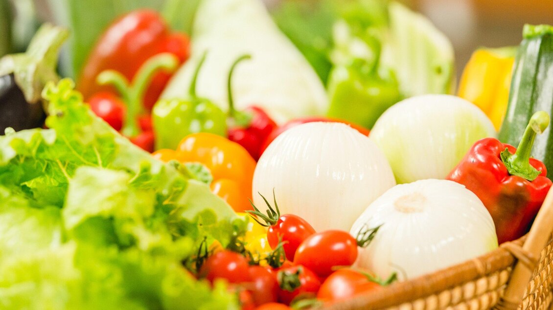 Ein Korb mit frischem Gemüse, darunter Paprika, Zwiebeln, Tomaten und Salat. Die bunten Farben verleihen dem Bild eine einladende und gesunde Atmosphäre. | © AMA GENUSS REGION - Mias Photoart
