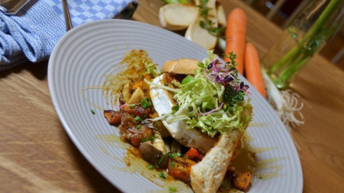  Teller mit gebratenen Ziegenkäse auf Ofengemüse, Blattsalat und geröstetem Brot. | © PEP