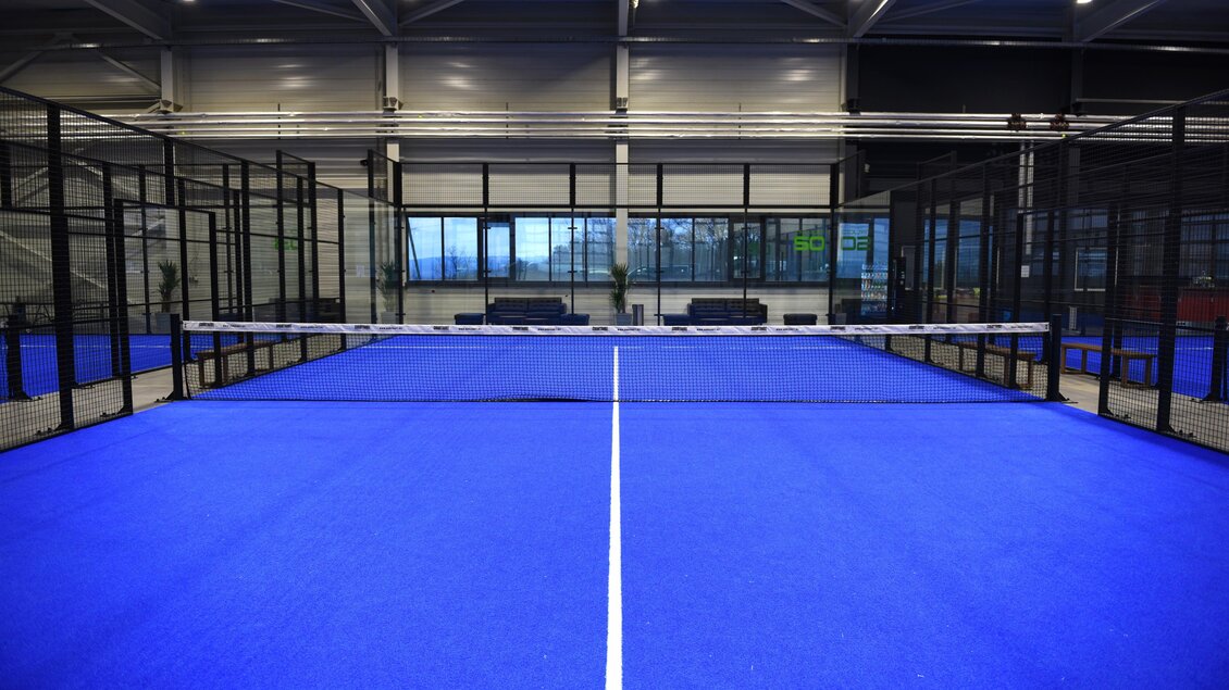 Blick auf einen blauen Padelplatz mit Glaswänden in der Halle in Kainbach bei Graz. | © Alexander Veit