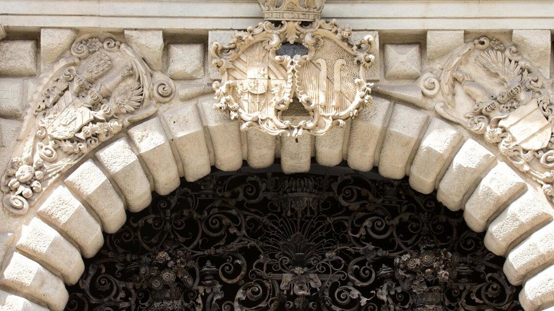 Barocke Wappenreliefs und schmiedeeisernes Gitter über dem Portal des Palais Saurau. | © Graz Tourismus-Harry Schiffer