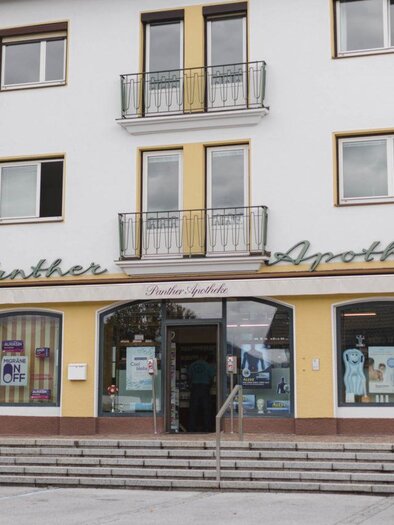 A modern pharmacy building with a large window front. Above the entrance is the inscription "Panther Pharmacy". | © Panther Apotheke