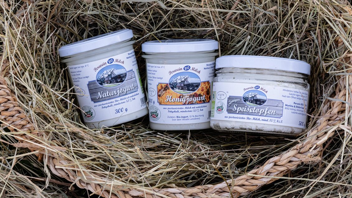 Drei Gläser mit verschiedenen Produkten stehen in einem Weidenkorb. Die Gläser sind mit Etiketten versehen und liegen auf trockenem Heu. | © Martina Siebenhandl