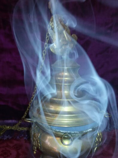 Ein goldfarbener Weihrauchbehälter mit Rauch, der aus ihm aufsteigt. Der Hintergrund ist dunkel und verleiht dem Bild eine mystische Atmosphäre. | © Pfarrer Brandstätter
