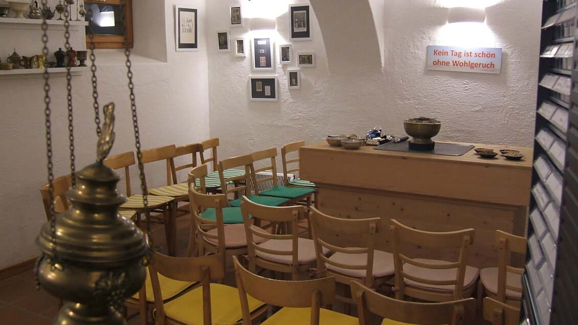 Ein gemütlicher Raum mit Holzstühlen und einem langen Tisch. An den Wänden hängen Bilder und Kunstgegenstände. | © Pfarrer Brandstätter