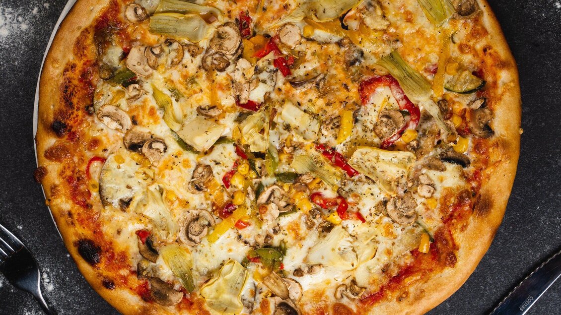 Eine leckere Pizza mit Artischocken, Paprika und Pilzen. Der Käse ist goldbraun und die Kruste ist knusprig. | © Arvideo