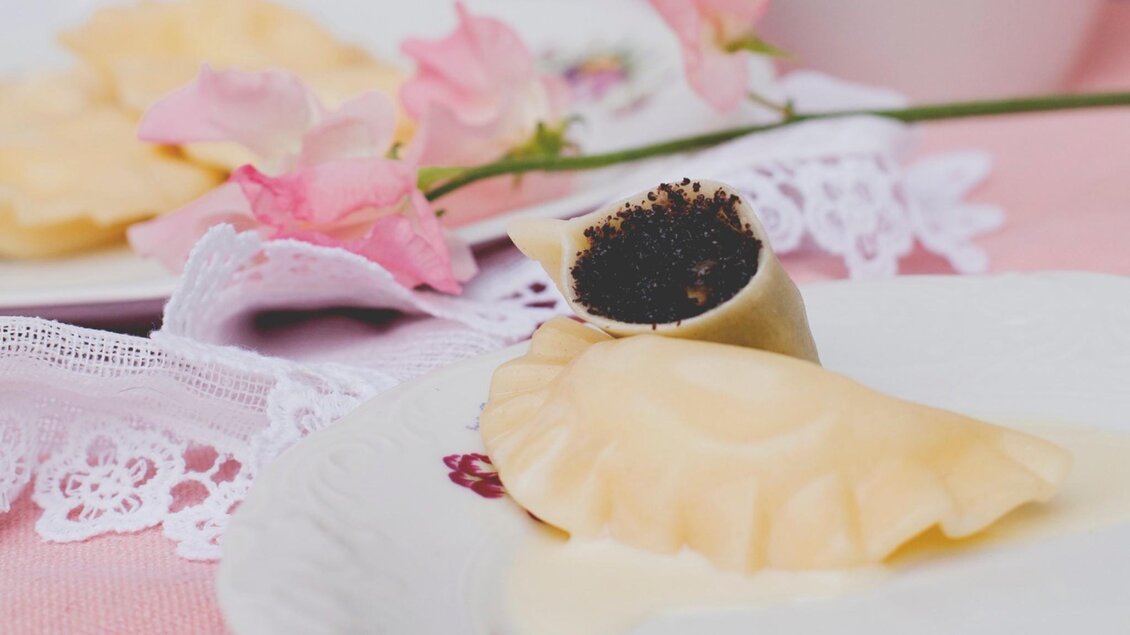 Ein ansprechendes Arrangement aus Gebäck, rosa Blumen und einer Tasse. Die gemütliche Atmosphäre lädt zum Genießen ein. | © Pierogi