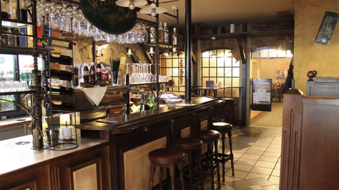 Eine gemütliche Bar mit Holzinterieur und Stühlen. Im Hintergrund sind Gläser und Getränke an der Theke sichtbar. | © Pizzeria Fratelli