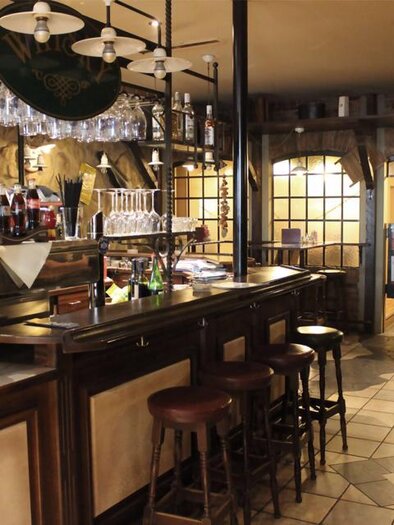 Eine gemütliche Bar mit Holzinterieur und Stühlen. Im Hintergrund sind Gläser und Getränke an der Theke sichtbar. | © Pizzeria Fratelli