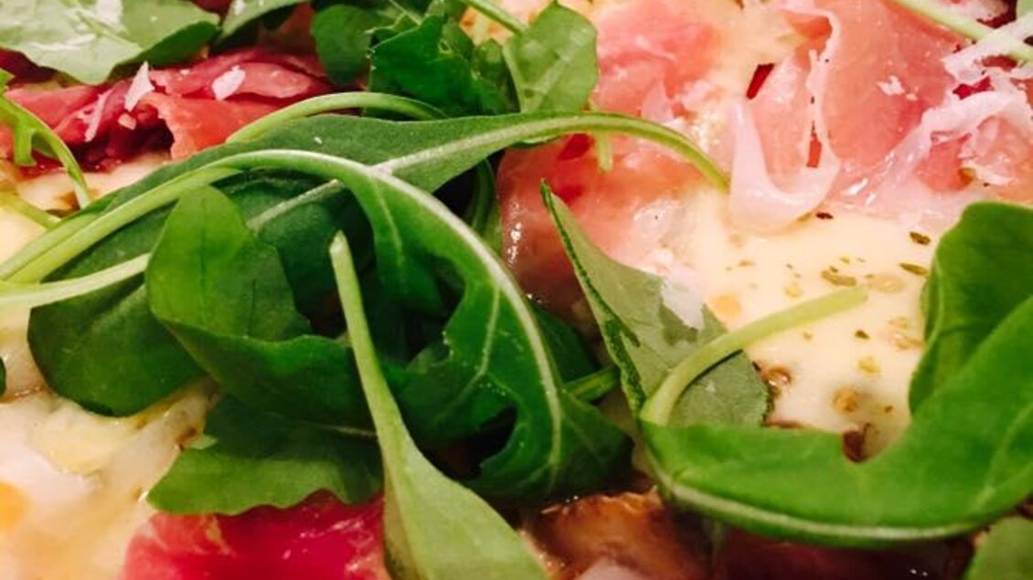 Eine leckere Pizza mit Schinken und frischem Rucola. Die Kombination aus Zutaten ergibt ein appetitliches Bild. | © Pizzeria Fratelli