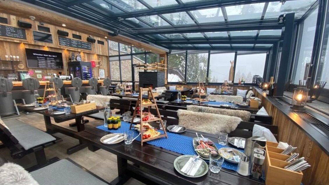 Ein gemütliches Restaurant mit großen Fenstern und rustikalem Holzinterieur. Tische sind schön gedeckt mit verschiedenen Speisen und Getränken. | © Planaihof