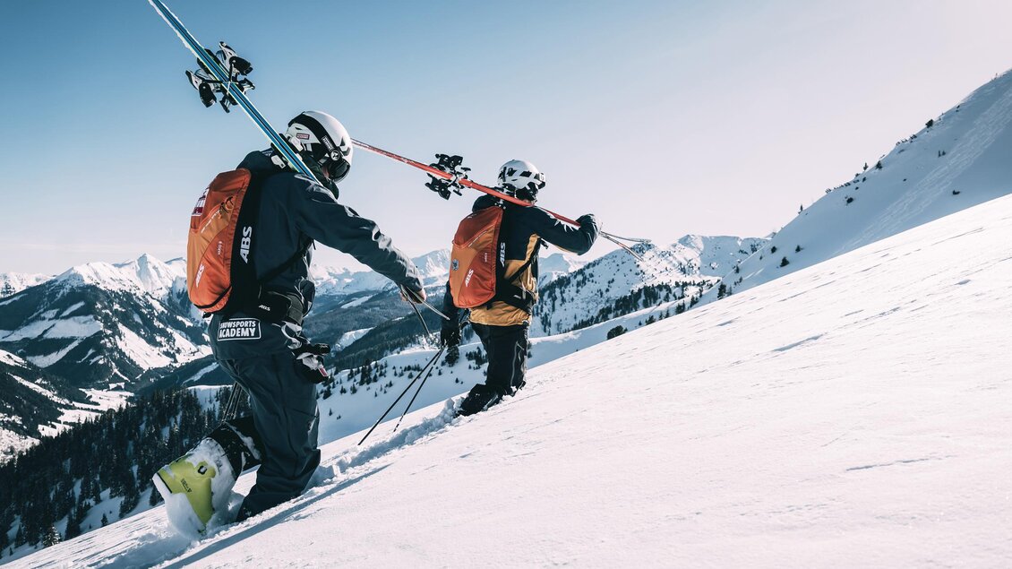 Zwei Skifahrer steigen einen schneebedeckten Hang hinauf. Im Hintergrund sind schneebedeckte Berge zu sehen. | © Armin Walcher