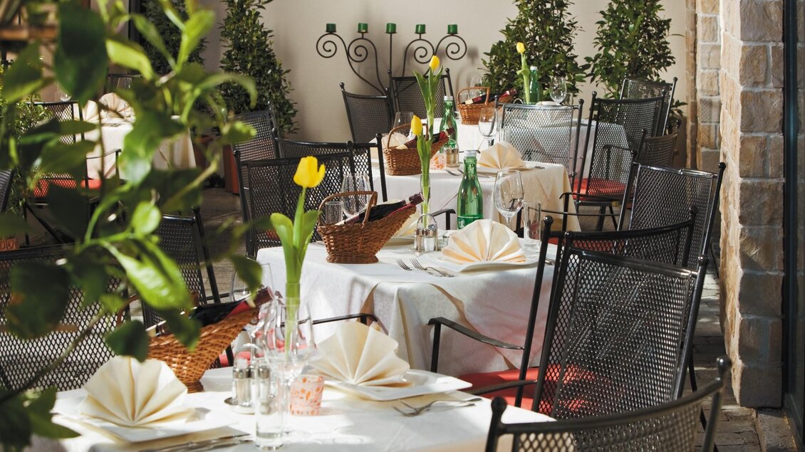 Elegant gedeckte Gartenterrasse des Restaurants Römerstube Graz mit Blumen und Tischdeko. | © Römerstube