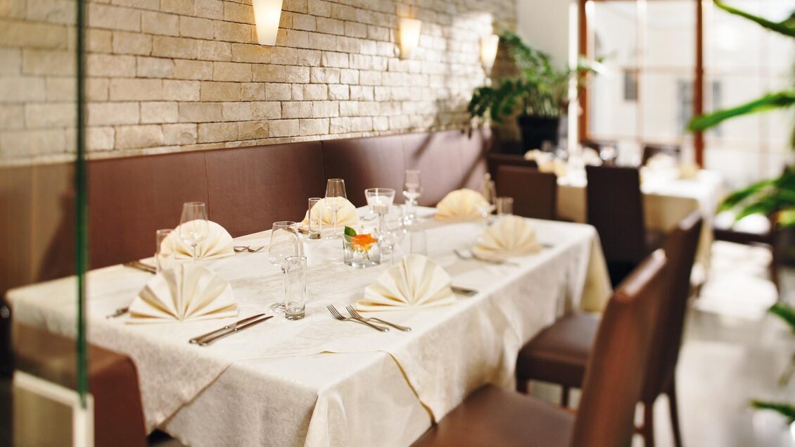 Innenraum des Restaurants Römerstube Graz mit festlich gedeckten Tischen und warmer Beleuchtung. | © Römerstube