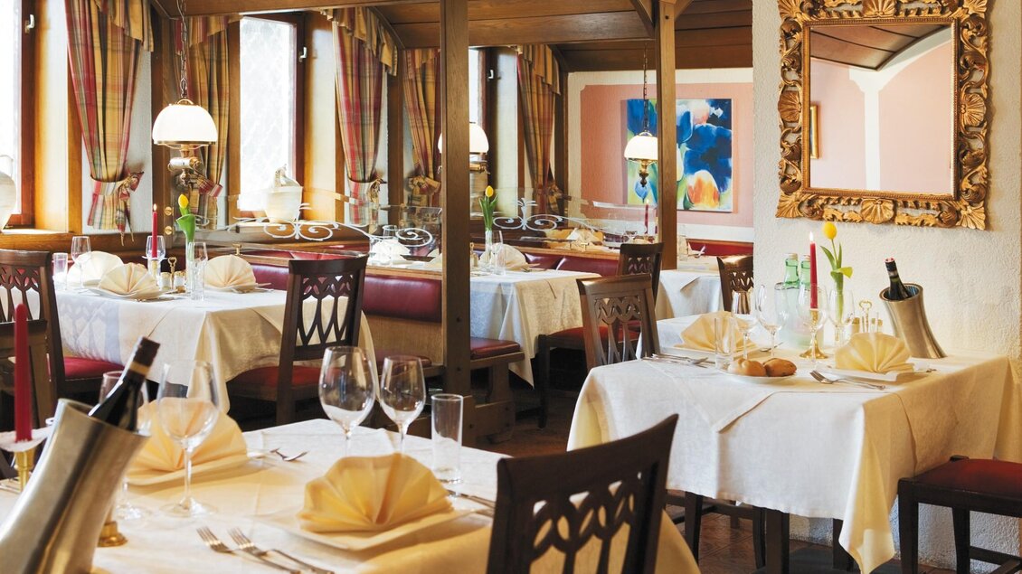 Innenraum der Römerstube Graz mit gedeckten Tischen, Spiegel und warmem Holzdekor. | © Römerstube