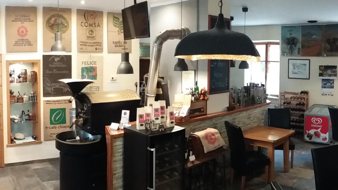 Ein gemütliches Café mit Holztischen und moderner Einrichtung. An den Wänden hängen Kunstwerke und Bilder. | © Röststation