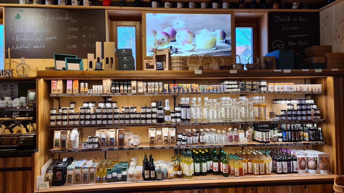 Ein gut sortierter Markt mit einer Vielzahl von Flaschen und Gläsern auf einem Holztisch. Auf dem Bildschirm im Hintergrund sind Früchte zu sehen. | © Tourismusverband Oststeiermark