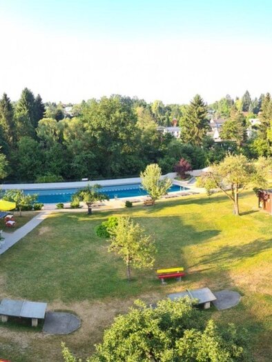 At Ragnitzbad, there is plenty of green space to relax. Next to the pool, there are seating areas and some colorful cabins. | © Ragnitzbad