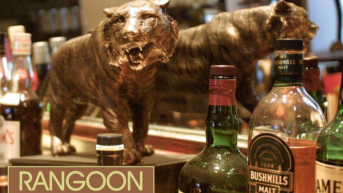 Detailaufnahme der Rangoon Bar Graz mit Flaschen, Bronzefigur und Spiegeldeko. | © Rangoon