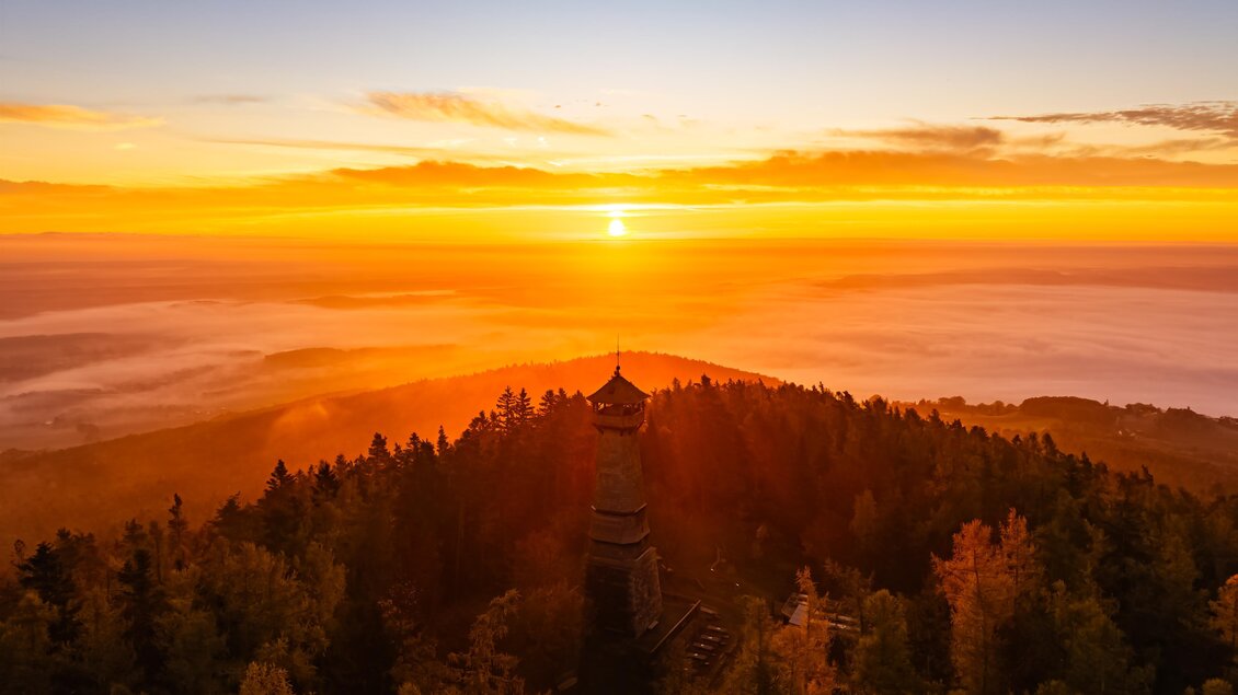 Ein wunderschöner Sonnenaufgang über einem Wald mit sanften Hügeln. Die warmen Farben des Himmels reflektieren die Ruhe der Natur. | © Oststeiermark Tourismus