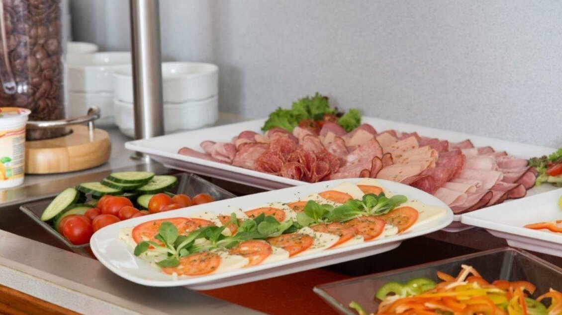 Ein Buffet mit verschiedenen Aufschnittsorten, frischem Gemüse und Tomaten. Die Platten sind ansprechend angerichtet und bieten eine Vielzahl an Auswahlmöglichkeiten. | © Handler