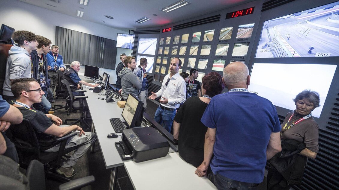 Eine Gruppe von Menschen steht in einem Kontrollraum mit vielen Bildschirmen. Sie beobachten und diskutieren verschiedene Szenarien auf den Monitoren. | © Philip Platzer