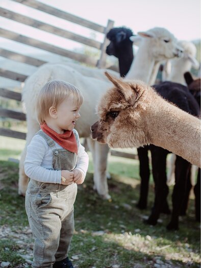 Reich Quellengut_child with alpaca_Eastern Styria | © Hadas Natural Photography