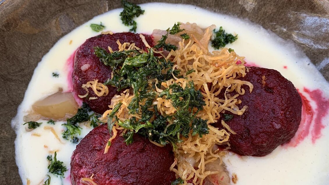 Ein schmackhaftes Gericht mit rote Beete-Bällchen in einer cremigen Sauce. Es ist garniert mit frischen Kräutern und knusprigen Fäden. | © Tauroa GmbH