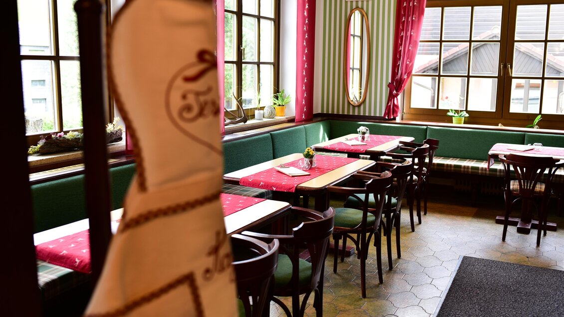 Ein gemütliches Restaurant mit grünem Mobiliar und Tischdecken in Rot. Große Fenster lassen viel Licht herein und schaffen eine einladende Atmosphäre. | © Erlebnisregion Murtal
