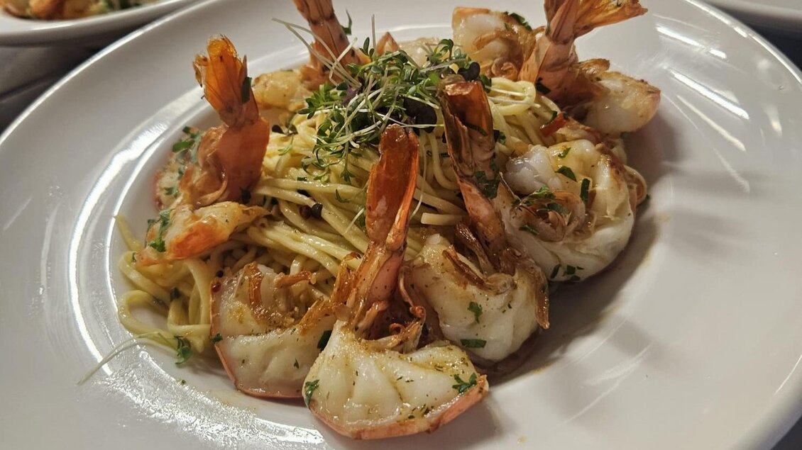 Ein Teller mit Spaghetti und geschälten Garnelen ist schön angerichtet. Frische Kräuter verleihen dem Gericht eine ansprechende Note. | © Michael Mauser